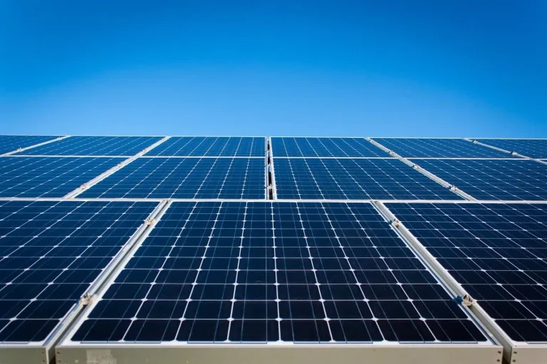 Solar panels tilted toward the sun under a clear Canadian sky